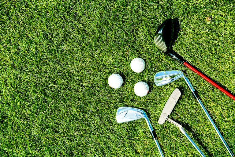 golf-clubs-and-balls-on-green