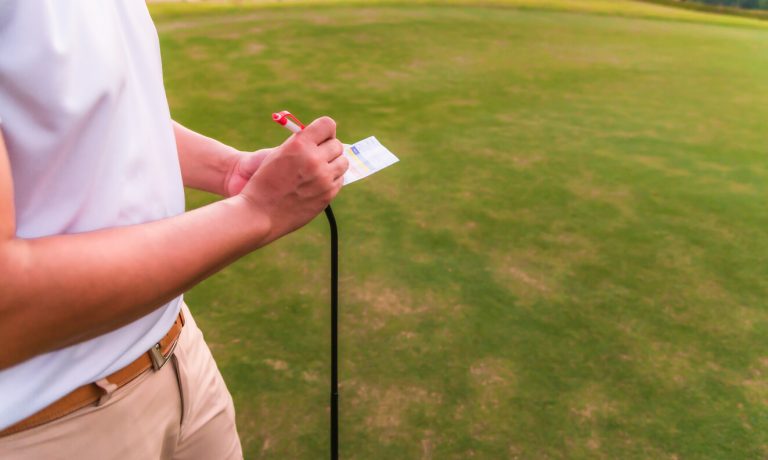 marking-golf-card-on-green