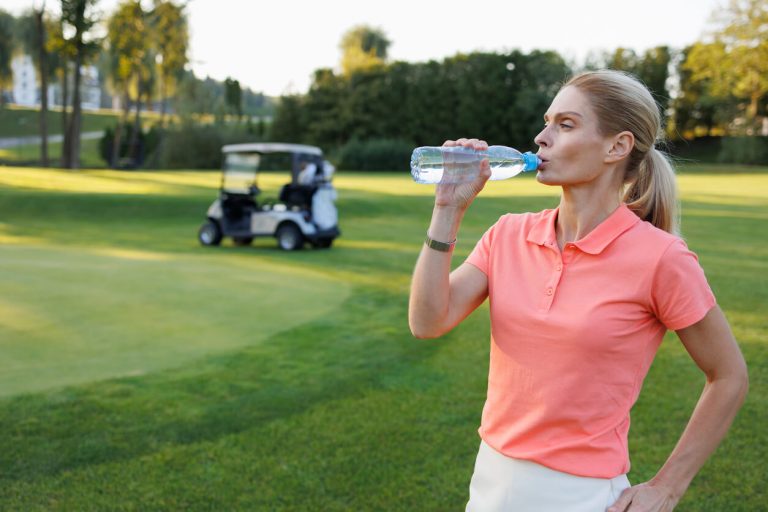 woman-drinking-water-on-golf-course