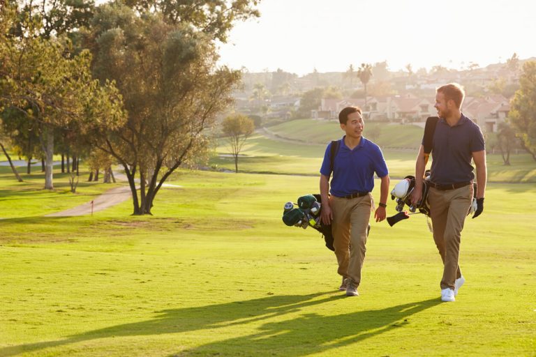 two-men-walking-on-golf-green